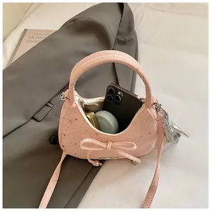 Detail van roze mini-tas met zilveren sterren en strik die de binnenopslag laat zien