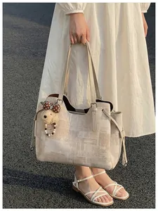 Détails du sac fourre-tout beige avec motifs géométriques et charmant ours en peluche