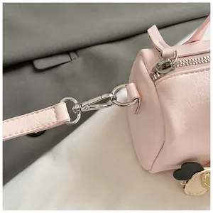 Dettaglio della borsa Boston rosa con cerniera argentata e ciondolo a forma di cuore