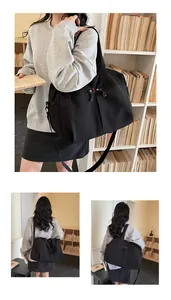 Dettaglio della borsa da viaggio grande in tela nera con tasche a zip e tracolla sportiva