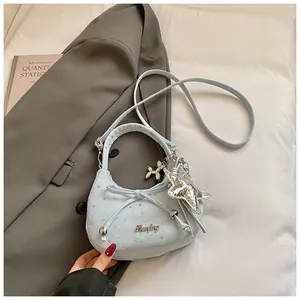 Detail van de hemelblauwe halvemaanvormige tas met sterrenpatroon en metalen hangers