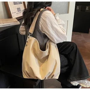 Detail van de grote canvas tas met brede schouderband en metalen klinknageldetails