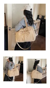 Dettaglio della borsa da viaggio in tela beige con doppie tasche a zip e tracolla robusta
