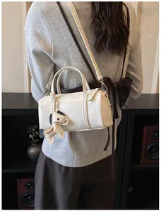 Borsa Boston in pelle bianca con ciondolo a cavallo indossata in un look casual