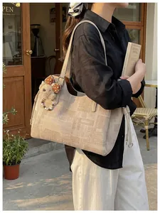 Détail du sac cabas jacquard géométrique avec charm ours et nœud à pois