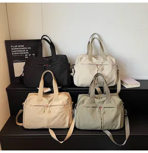 Dettaglio di borse da viaggio in tela capienti in nero, beige, kaki e verde militare