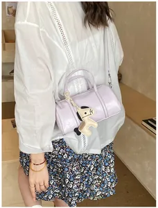 Dettaglio borsa Boston viola chiaro con ciondolo a forma di pony e manico intrecciato