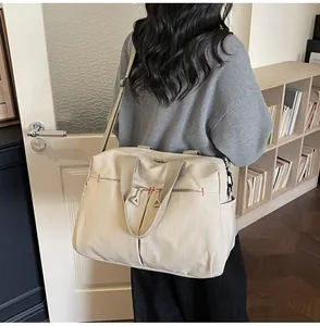 Dettaglio borsa da viaggio in tela con cuciture rosse rinforzate e cerniere resistenti