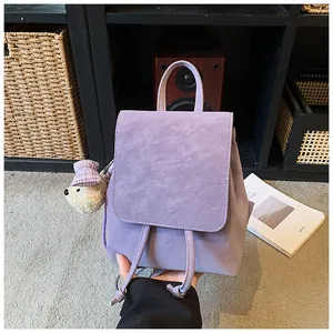 Detail of lavender textured faux leather backpack with drawstring and plush bear charm