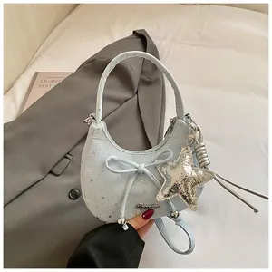 Detail van lichtblauwe halve maan tas met sterrenprint en metalen ster hanger