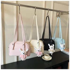 Detailed view of four colors of lychee pattern crossbody bags with cute rabbit pendants