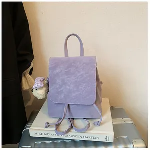 Detail of light purple leather backpack with drawstring closure and cute bear charm