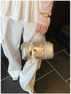 Dettaglio di una borsa Boston argento metallizzato con texture plissettata e ciondolo