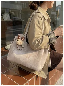 Détail du grand sac cabas en toile beige avec motif abstrait et breloque chien peluche