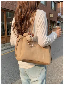 Détail du cabas en toile avec lanières en cuir et breloque chiot en peluche mignonne