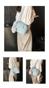 Close-up of light blue lychee pattern crossbody bag with a cute rabbit plush pendant