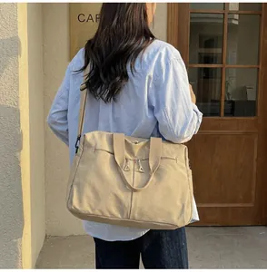 Modello con borsa da viaggio in tela kaki con cuciture rosse e tracolla nera