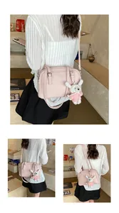 Pink litchi texture square bag shown on model with a cute plush rabbit charm