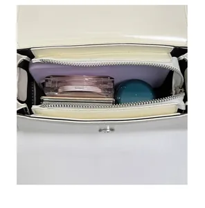 Interior view showing the storage capacity of a white leather crossbody bag with compartments
