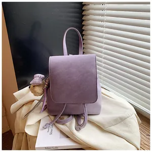 Detail of lavender mini backpack with plush bear pendant in soft natural window light