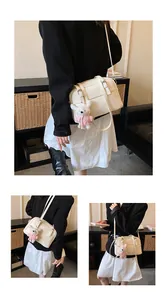 Detail of beige litchi grain Boston bag with a cute pink rabbit plush charm on the side