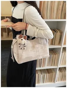 Détail du cabas en toile beige à carreaux avec charm de chien en peluche doux