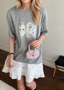 Pink heart-embellished mini handbag paired with a grey puppy print tee and white lace skirt