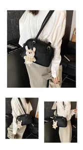 Detail of black lychee grain leather crossbody bag with cute rabbit plush charm and strap