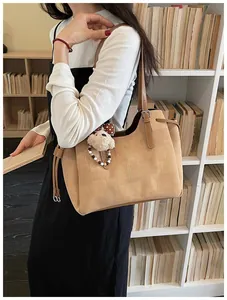 Détail du sac cabas kaki avec pendentif ours en peluche et cordon de serrage latéral