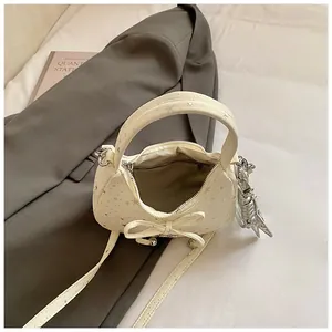 Detailweergave van de crèmewitte canvas tas met sterrenprint en metalen hanger