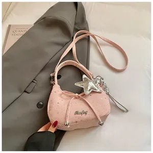 Detailopname van roze schoudertas met zilveren sterren en strik op een blazer