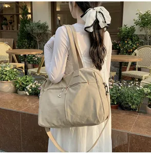 Dettaglio di una borsa da viaggio in tela con tasche a cerniera e tracolla regolabile
