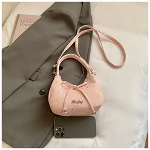 Roze handtas met strik en zilveren sterren op grijze blazer in lifestyle-setting