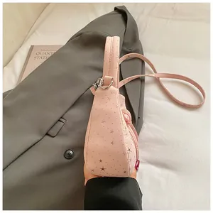 Detail van roze crossbodytas met zilveren sterpatronen en verstelbare schouderriem