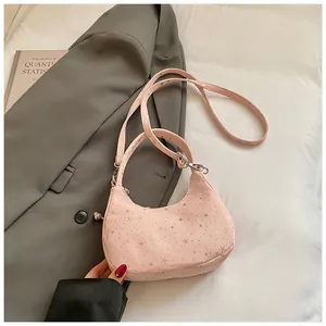 Detailopname van de roze halvemaanvormige crossbodytas met sterpatronen en zilveren studs