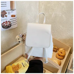 Detailed view of white PU leather backpack with drawstring closure and cute bear pendant