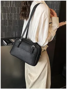 Detail shot of black litchi pattern leather shoulder bag with sleek silver hardware