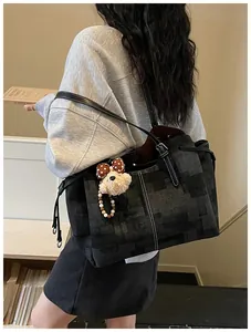 Détail du grand sac cabas gris avec texture vintage, couture blanche et petit ours