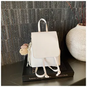 Close-up of white PU leather backpack with drawstring closure and cute bear charm