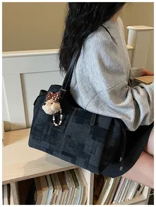 Gros plan du sac cabas en toile grise texturée avec porte-clés ours en peluche