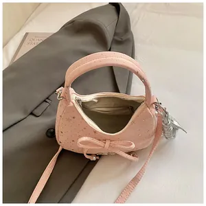 Detail van de roze halvemaanvormige tas met zilveren sterren en een zoete strik