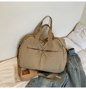 Dettaglio della borsa da viaggio in tela kaki con tasche a zip e tracolla regolabile