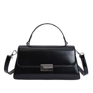 Elegant black glossy crossbody handbag with silver buckle and curved handle for daily commute