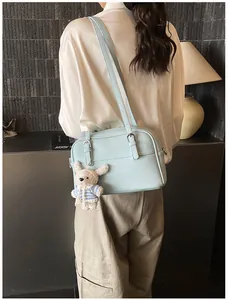 Close-up of light blue lychee pattern crossbody bag with cute plush bunny charm detail