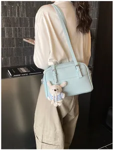 Model showing a light blue lychee pattern shoulder bag with a cute white bunny pendant