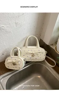 Cream floral handbags with bow and heart charms in large and small sizes on display