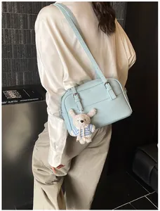 Detail of light blue lychee pattern leather shoulder bag with cute plush rabbit charm