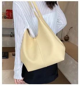 Close-up of cream faux leather tote bag showing high-quality lychee texture and stitching
