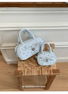 Close-up of light blue floral handbag set with bow accents and heart pendants
