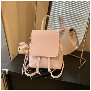 Close-up of pink PU leather backpack with drawstring closure and cute plush bear charm